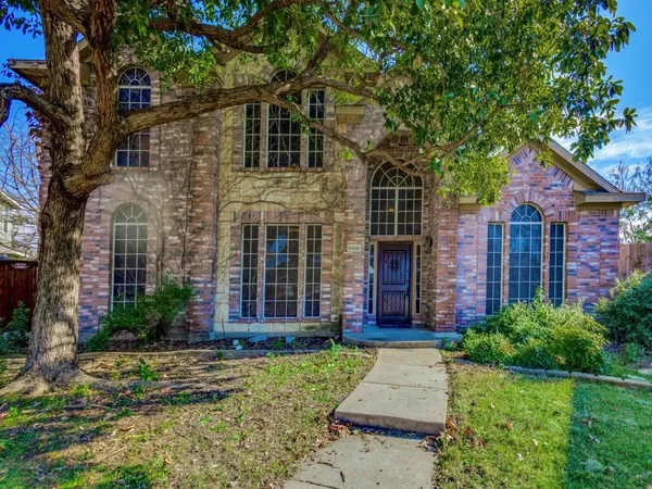 front view of a brick house with a yard