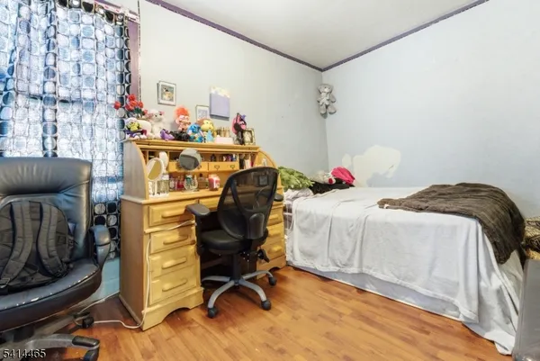 a bedroom with bed and wooden floor