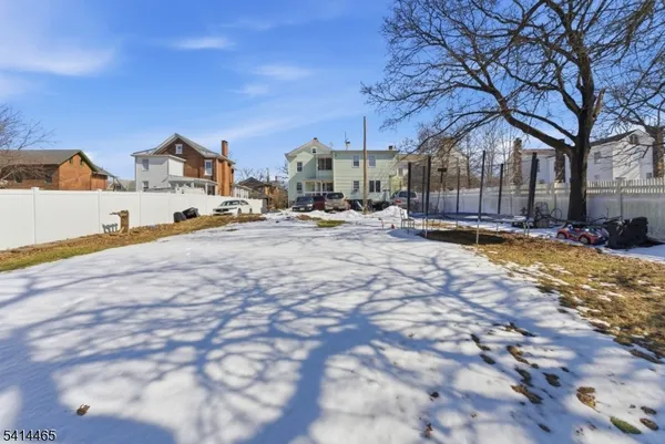 a view of large house with a yard covered in snow