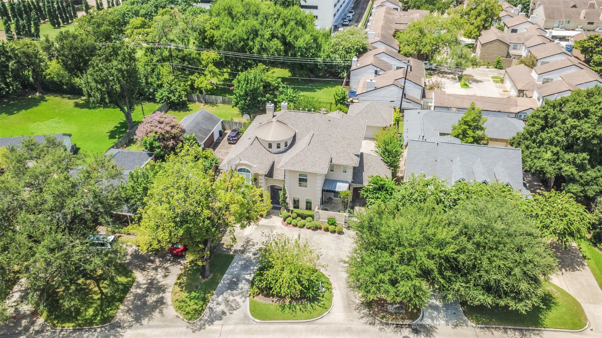 Aerial view of the property showing the lush backyard and u-shaped driveway