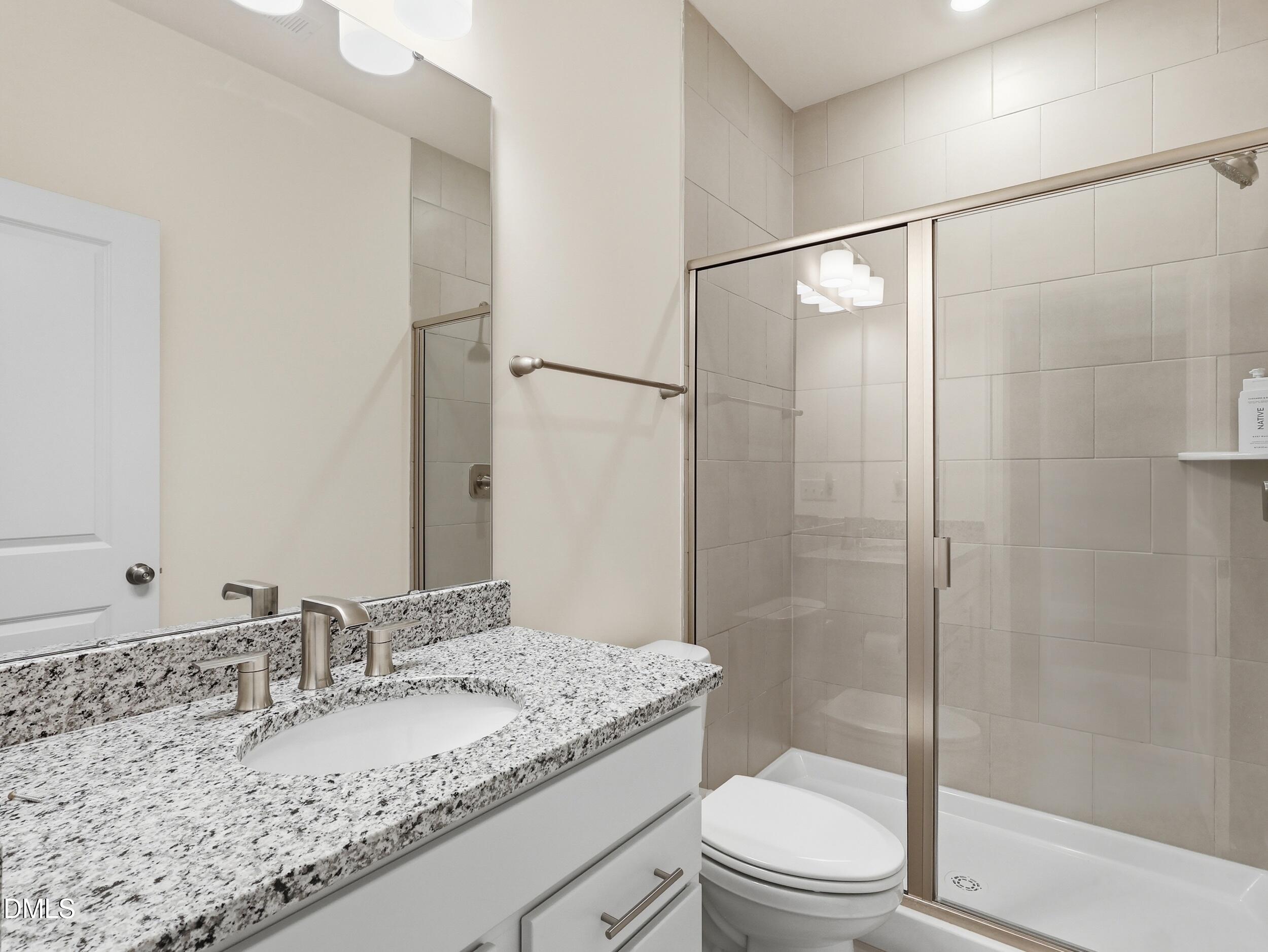 2709 Womble Ridge Drive New Hill, NC 27562 - Photo 23 of 60 a bathroom with a granite countertop sink toilet and shower