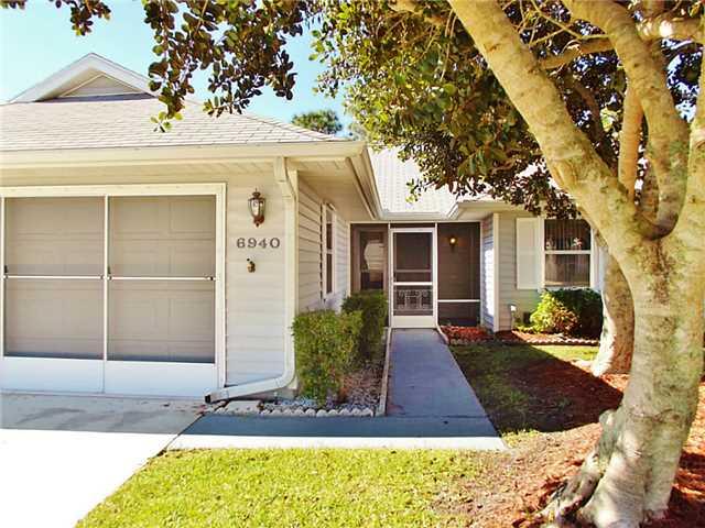6940 Southeast Lillian Court Stuart, FL 34997 - Photo 1 of 25 a front view of a house with garden