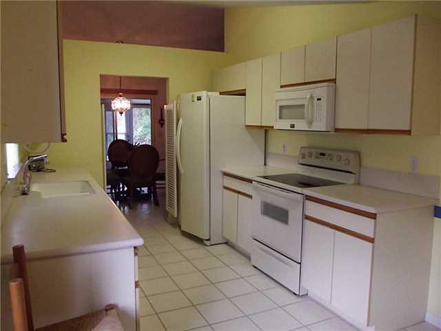 6940 Southeast Lillian Court Stuart, FL 34997 - Photo 12 of 25 a kitchen with a refrigerator sink and cabinets