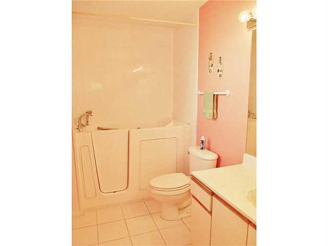 6940 Southeast Lillian Court Stuart, FL 34997 - Photo 18 of 25 a bathroom with a granite countertop bathtub and a toilet