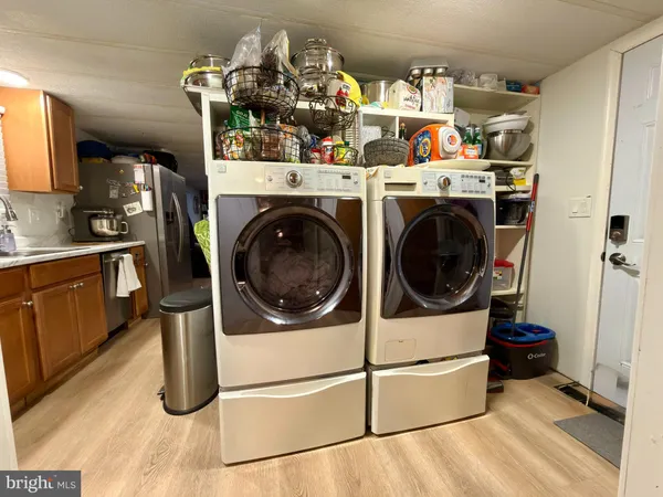 a utility room with dryer washer and a view of living room