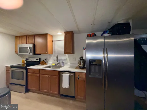 a kitchen with stainless steel appliances granite countertop a sink a stove and a refrigerator