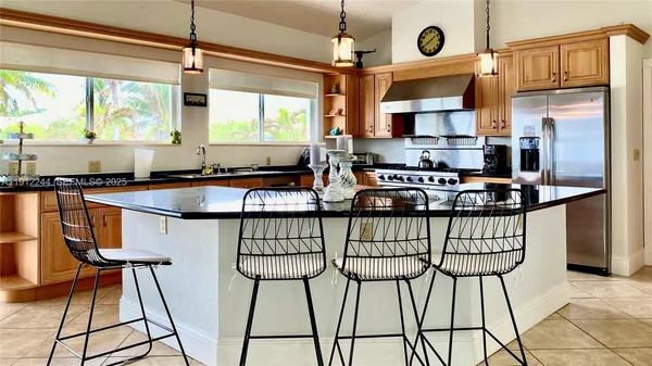 a kitchen with stainless steel appliances kitchen island granite countertop a sink and cabinets
