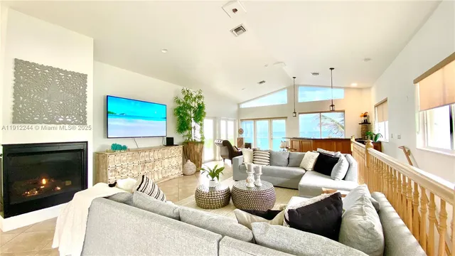 a living room with furniture a fireplace and a flat screen tv