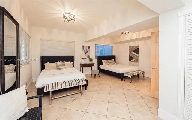 a bedroom with a bed and a large window with a chandelier