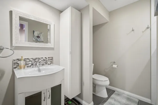 a bathroom with a toilet a sink and a mirror