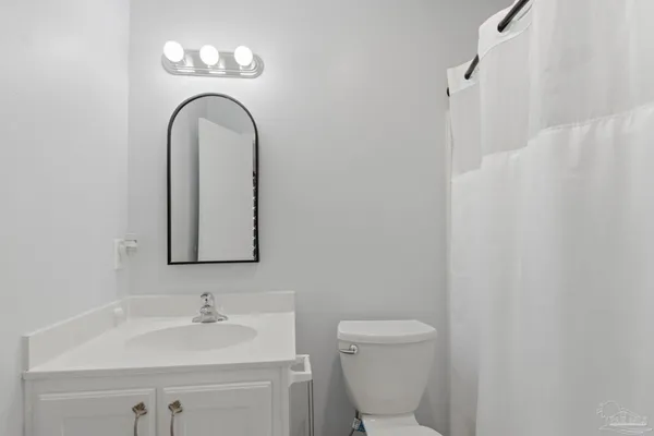a bathroom with a toilet a sink and mirror