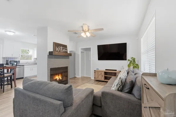 a living room with furniture a fireplace and a flat screen tv