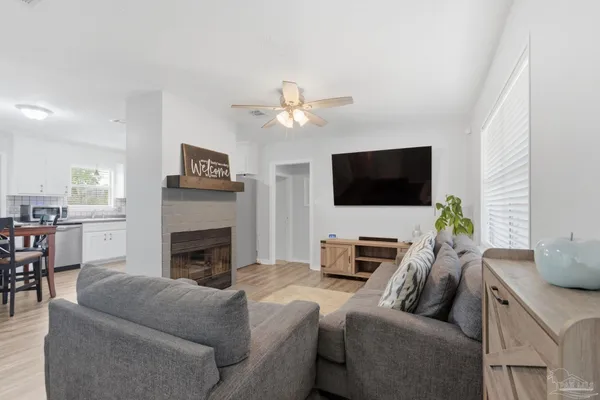 a living room with furniture a fireplace and a flat screen tv