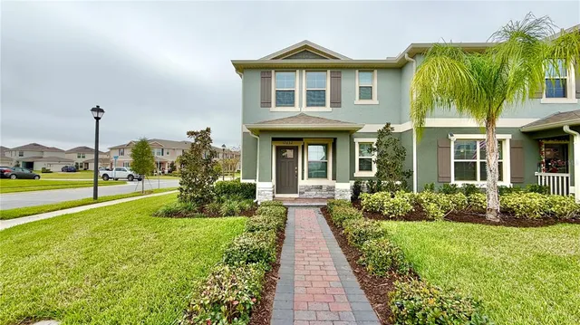 a front view of a house with a yard and potted plants