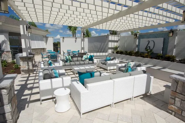 a view of a patio with couches table and chairs under an umbrella