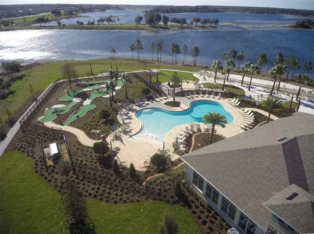 an aerial view of a house with swimming pool and ocean view