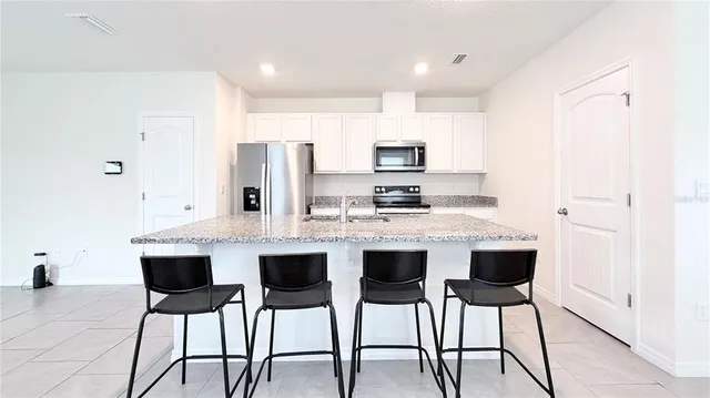 a kitchen with kitchen island cabinets and chairs in it