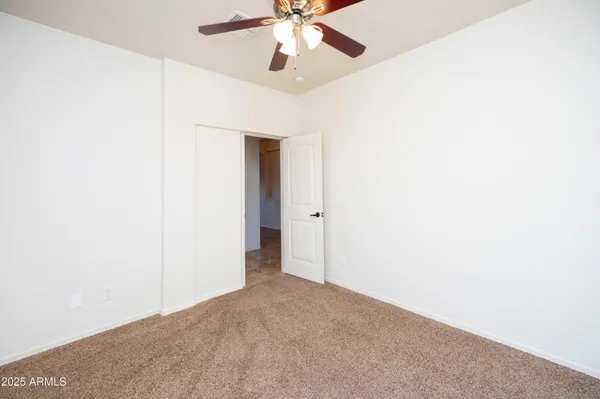 an empty room with a ceiling fan and a fan