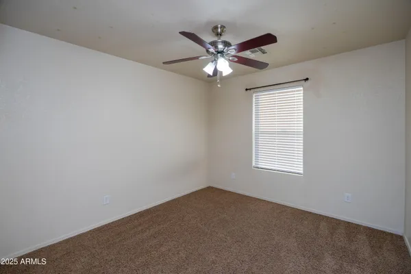 a view of an empty room with a ceiling fan