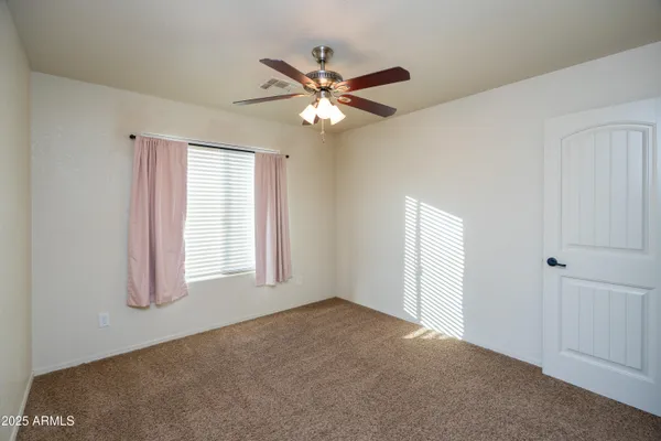 wooden floor in an empty room and a chandelier fan
