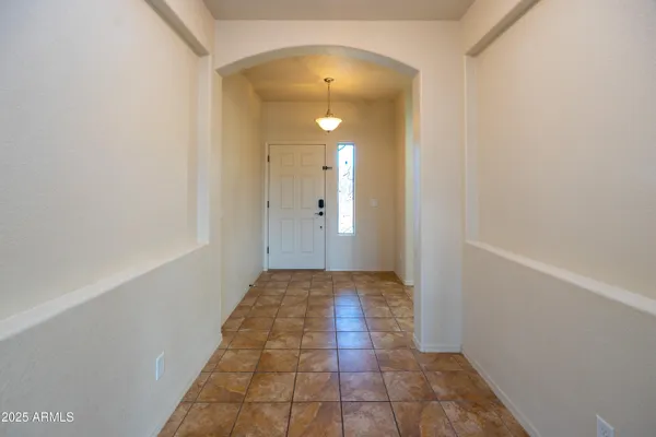 a view of a hallway with wooden floor and a bathroom