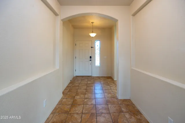 a view of a hallway with wooden floor and a bathroom