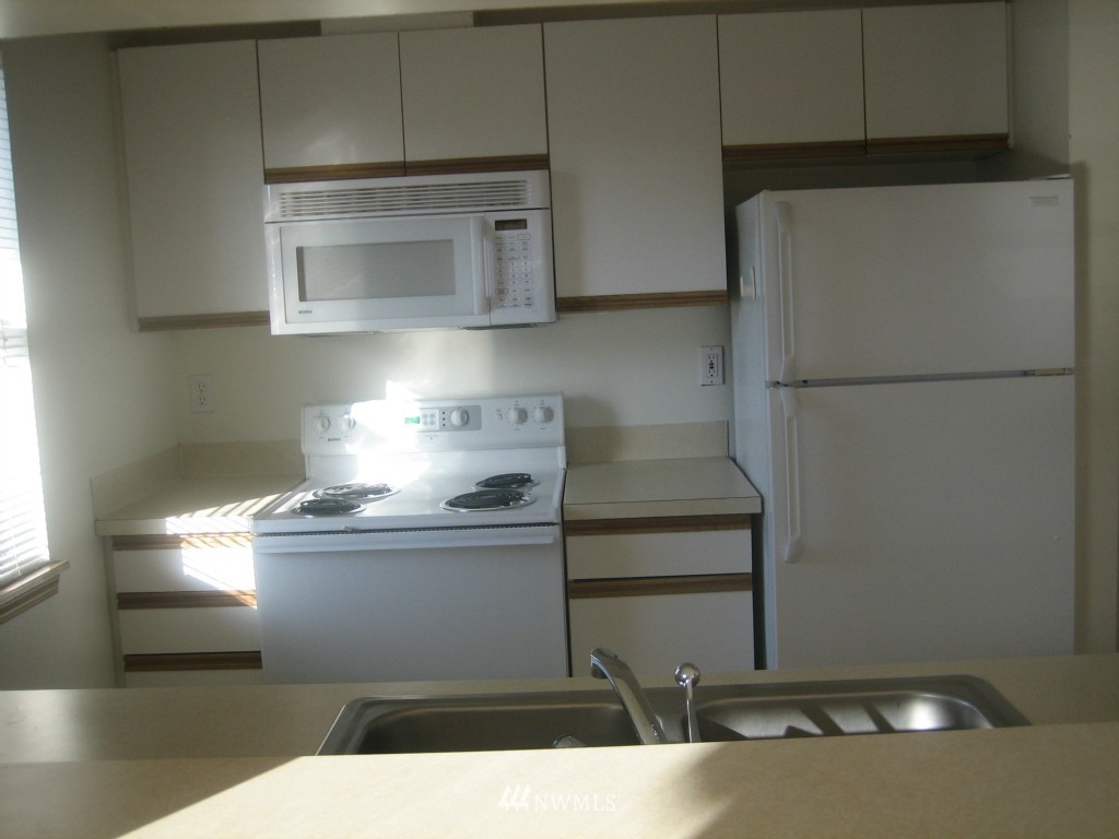703 North 95th Street Seattle, WA 98103 - Photo 6 of 11 a kitchen with stainless steel appliances a refrigerator and a stove top oven
