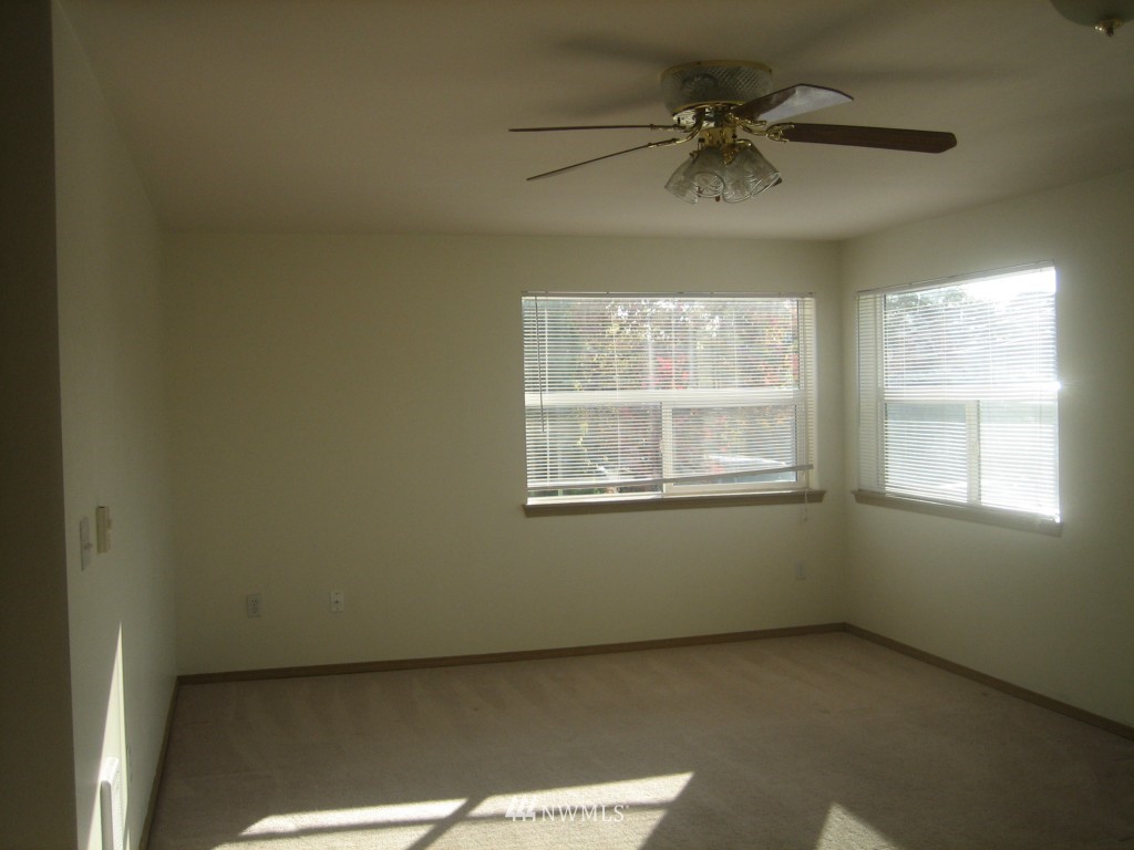 703 North 95th Street Seattle, WA 98103 - Photo 9 of 11 an empty room with a window and a ceiling fan