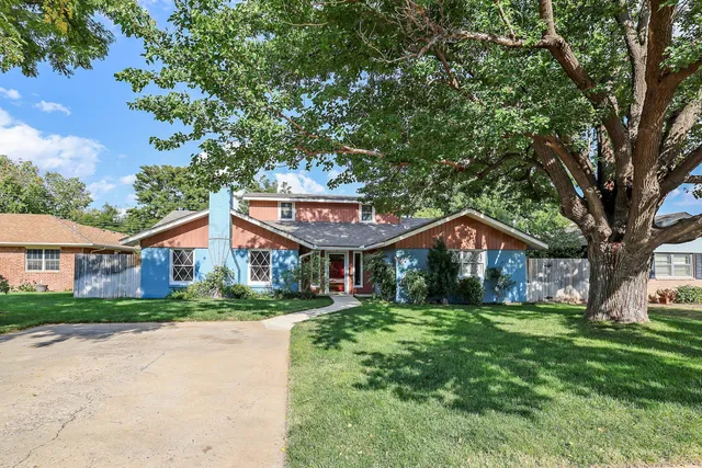 a front view of a house with yard and green space