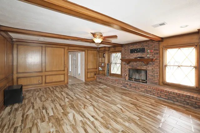 a view of an empty room with a fireplace and a window