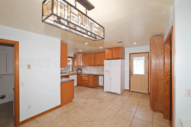 a view of a kitchen with a refrigerator and a sink