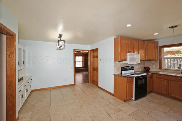 a kitchen with stainless steel appliances granite countertop a stove a sink dishwasher and a refrigerator
