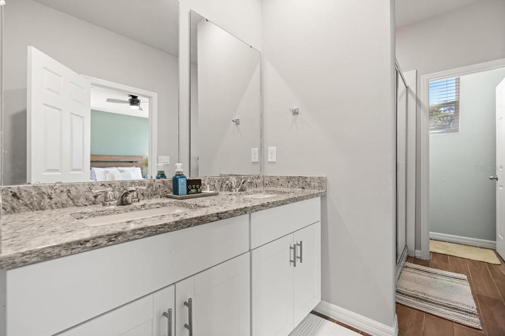 140 South Zuni Road St. Cloud, FL 34771 - Photo 19 of 35 a bathroom with a granite countertop sink and a mirror