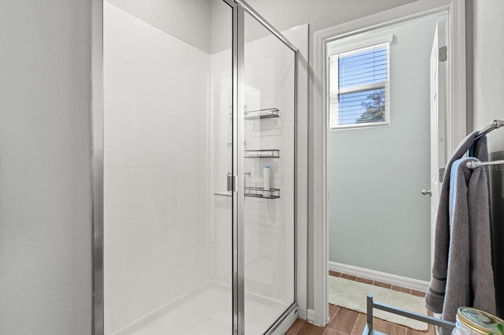 140 South Zuni Road St. Cloud, FL 34771 - Photo 20 of 35 a bathroom with a glass shower door
