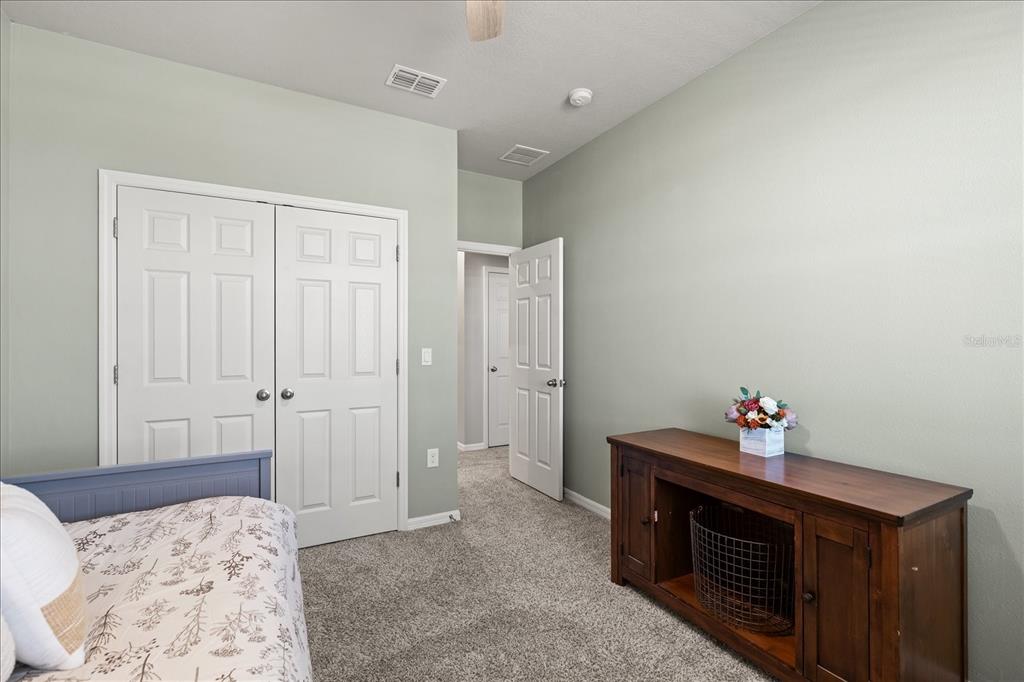 140 South Zuni Road St. Cloud, FL 34771 - Photo 25 of 35 a bedroom with a bed and cabinets