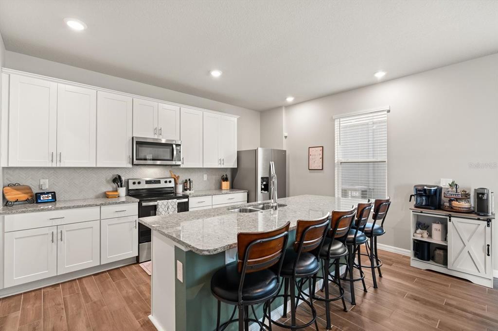 140 South Zuni Road St. Cloud, FL 34771 - Photo 9 of 35 a kitchen with stainless steel appliances a table and chairs in it