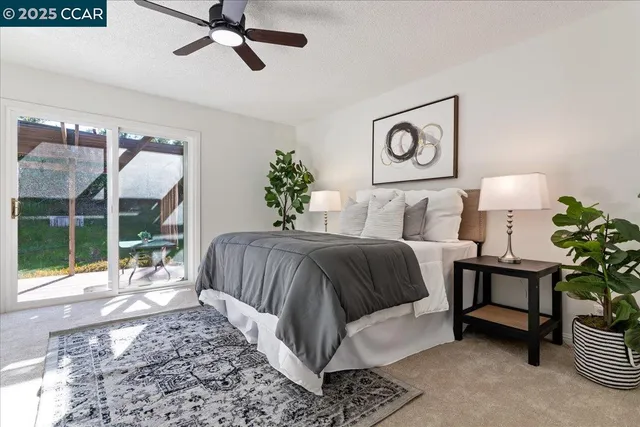 a bedroom with a bed a potted plant and a dresser
