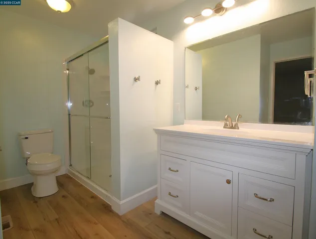 a bathroom with a granite countertop sink toilet and shower