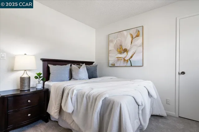 a bedroom with a bed and a painting on the wall