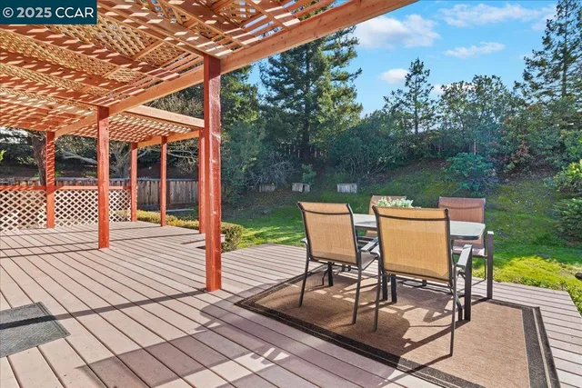 a view of a patio with wooden floor next to a yard
