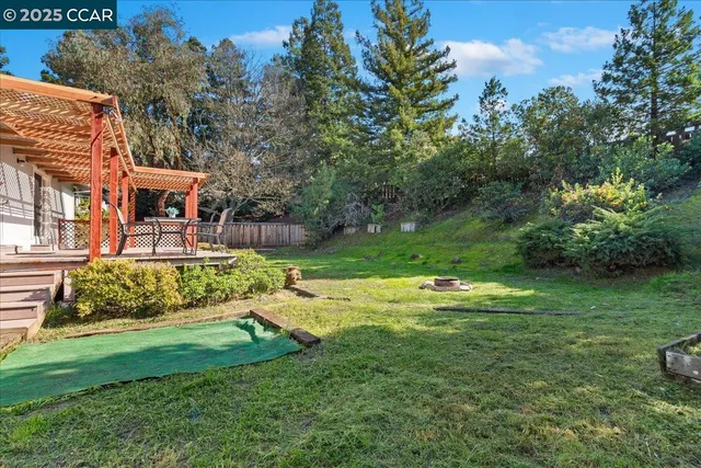 a view of a house with a big yard and a large tree