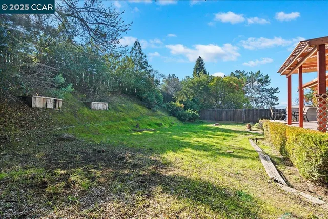 a view of a house with backyard and sitting area