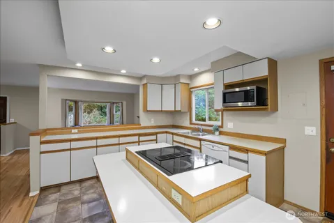 a kitchen with a stove and white cabinets