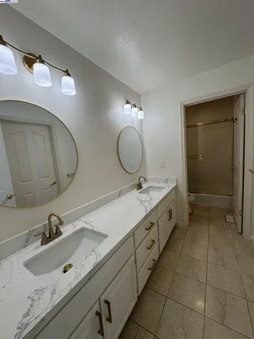 a bathroom with a double vanity sink and a mirror