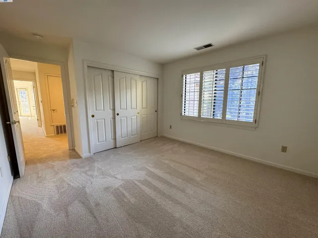 an empty room with windows and closet