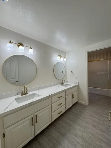 a spacious bathroom with double vanity and a mirror