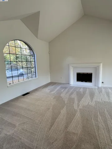 an empty room with a fireplace and windows