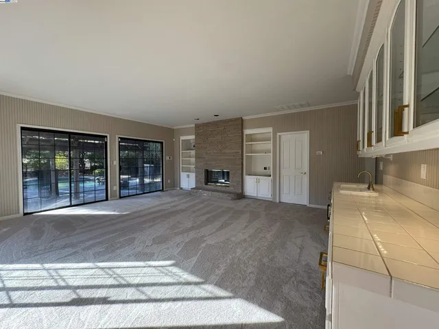 a view of an empty room with a fireplace and a large window
