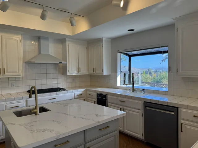 a kitchen with a sink a stove and cabinets