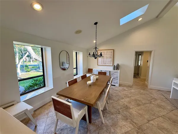 a living room with a table chairs and a window